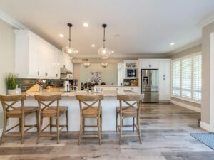 Bright and spacious kitchen interior featuring bar stools and modern design elements.