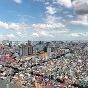 Aerial view of a bustling cityscape with towering buildings under a clear blue sky, perfect for urban exploration imagery.