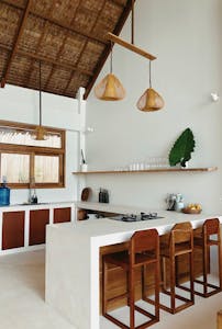 Stylish modern kitchen interior featuring wooden elements and minimalist decor. an interior shot of a tropical home featuring an open floor plan, high ceilings, and large windows
promoting cross-ventilation.